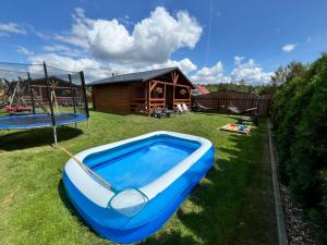 a blue inflatable boat sitting on the grass in front of a house at Domki pod Dębem in Wilkasy +4 photos