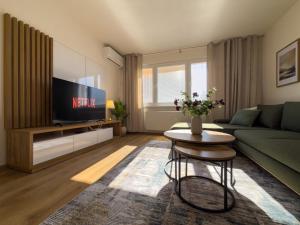 a living room with a green couch and a tv at The Elegant Hideaway in Šurany