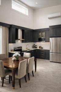 a kitchen with a wooden table and a refrigerator at Casamar in Uvita
