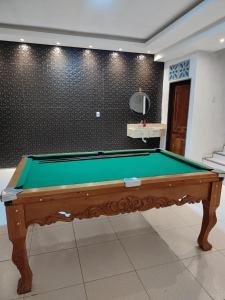 a green pool table in a room with a wall at Chácara Santa Teresinha Crato in Crato