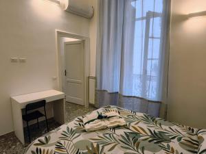 a bedroom with a bed and a desk and a window at Due Monelli in Naples