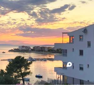 a sunset view of a building and a body of water at NEW Sunset Suite in Povljana