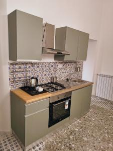 a small kitchen with a stove and a sink at Due Monelli in Naples