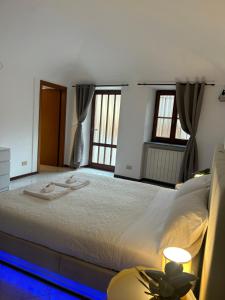 a large bed in a room with windows at Il Nido sul Lago B&B in Viverone