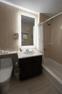 a bathroom with a sink and a toilet and a mirror at Grandview Hotel New York in Queens +28 photos