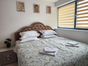 a bedroom with a large bed with two towels on it at Luxury apartment Avanera in Suceava