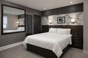 a bedroom with a large bed and a large mirror at Grandview Hotel New York in Queens