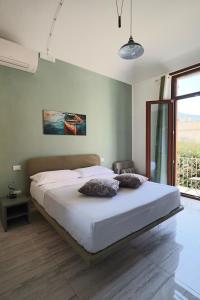 a bedroom with a bed with two pillows on it at Agorà di Favignana - Affittacamere Piazza Madrice in Favignana