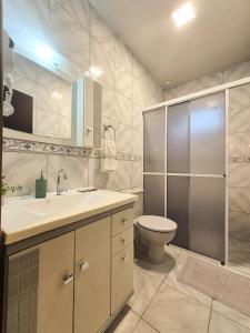 a bathroom with a toilet and a sink and a shower at Frieden Haus Hospedagem in Pomerode +39 photos