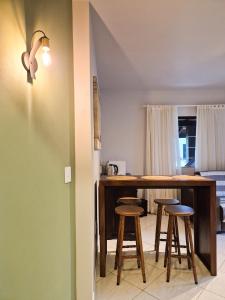 a kitchen with a counter and stools in a room at Frieden Haus Hospedagem in Pomerode