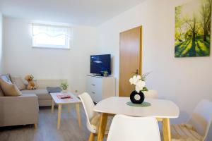 a living room with a table and a couch at Am Blumenladen in Lübben