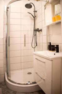 a white bathroom with a shower and a sink at Am Blumenladen in Lübben