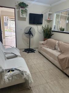 a living room with a couch and a fan at Casa Canto do Rio in Socorro