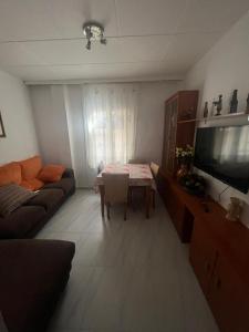 a living room with a couch and a tv and a table at La Morada del Jucar in Cuenca