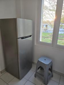 a kitchen with a stainless steel refrigerator and a stool at Séjour Eau Vive Proche commerces et Metro in Créteil