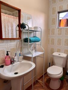 a bathroom with a sink and a toilet and a mirror at Luna Atacama in San Pedro de Atacama