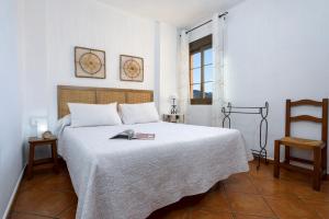 a bedroom with a bed and two chairs and a window at Apartamentos Sierra Tejeda in Alcaucín +94 photos
