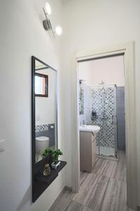 a bathroom with a mirror and a sink at Agorà di Favignana - Affittacamere Piazza Madrice in Favignana