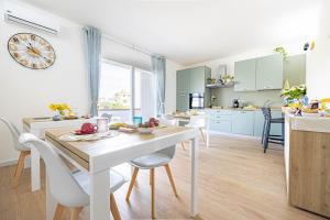 a kitchen and dining room with a white table and chairs at Corona Guest House in Sestu