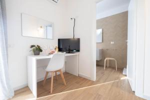 a white room with a desk and a chair at Corona Guest House in Sestu