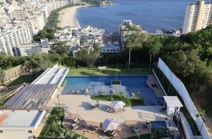 an aerial view of a building with a pool and a beach at Vista Espetacular e Estúdio Novo in Niterói