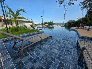 a pool of water with two benches in front of it at Vista Espetacular e Estúdio Novo in Niterói