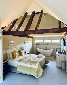 a bedroom with a large bed and a bath tub at Dingle Marsh Barns in Dunwich