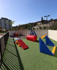 a playground with colorful slides and swings on grass at Vista Espetacular e Estúdio Novo in Niterói