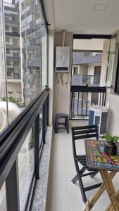 a balcony with a table and chairs and a window at Vista Espetacular e Estúdio Novo in Niterói