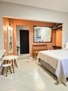 a bedroom with a bed and a table and chairs at Frieden Haus Hospedagem in Pomerode