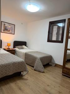 a hotel room with two beds and a window at Apartment 365 in Tivat
