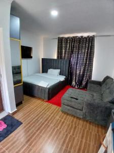 a living room with a bed and a couch at Jjhomes in Eldoret