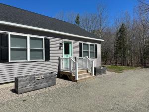 a small white house with a porch and a deck at Coastal Maine Escape in Ellsworth
