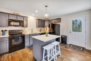a kitchen with gray cabinets and a white counter top at Coastal Maine Escape in Ellsworth +12 photos