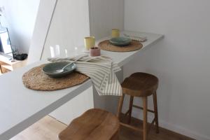 a kitchen with two counters with bowls and stools at Bohemian Beach Retreat in Donja Lastva +8 photos