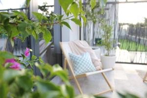 a chair sitting on a porch with potted plants at Bohemian Beach Retreat in Donja Lastva