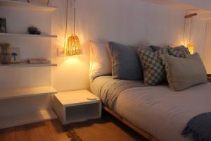 a living room with a couch with pillows and a lamp at Bohemian Beach Retreat in Donja Lastva