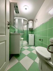 a green and white bathroom with a toilet and a sink at Apartment 365 in Tivat +36 photos