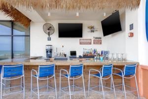 a bar with blue bar stools in a restaurant at Hampton Inn & Suites - Orange Beach in Orange Beach