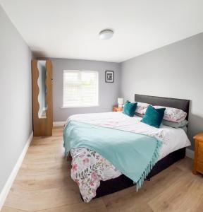 a bedroom with a large bed with blue pillows at killarney Townhouse with super location in Killarney