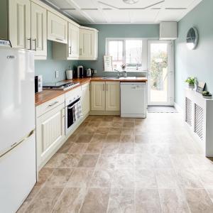 a kitchen with white cabinets and a tile floor at killarney Townhouse with super location in Killarney