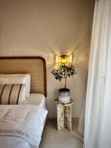 a bedroom with a bed and a potted plant on a table at Vida Lenta Boutique Finca in Alora +62 photos