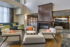 a lobby with chairs and a fireplace in a hotel at Hampton Inn & Suites Edmonton/West in Edmonton