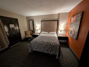 a hotel room with a bed and a desk at Hickory West Inn in Hickory Hills