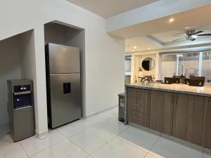 a kitchen with a stainless steel refrigerator next to a counter at Baja Ocean View 3 BR Panoramic Terrace & Private Jacuzzi 8pp in Rosarito