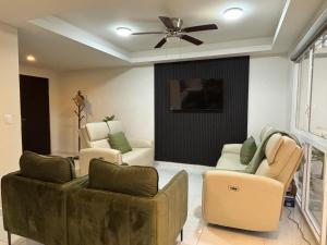 a living room with couches and chairs and a ceiling fan at Baja Ocean View 3 BR Panoramic Terrace & Private Jacuzzi 8pp in Rosarito