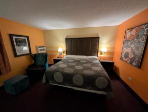 a bedroom with a large bed and a chair at Hickory West Inn in Hickory Hills +6 photos