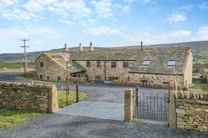 an old stone barn with a gate in front of it at 4 Bed in Cowling oc-h30773 in Cowling