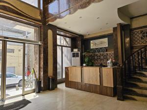 a living room with a kitchen and a staircase at Al-Mahasen Hotel in An Najaf