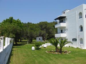a building with a grass yard next to a building at Maistrali Studios Skiathos in Koukounaries +25 photos